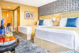 a hotel room with two beds and a bowl of fruit at Executive Plaza Hotel & Conference Centre, Metro Vancouver in Coquitlam