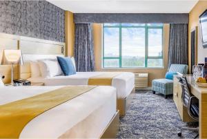 a hotel room with two beds and a window at Executive Plaza Hotel & Conference Centre, Metro Vancouver in Coquitlam