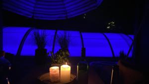 a table with two candles and a blue background at Pool & Lake Holiday Home in Markkleeberg