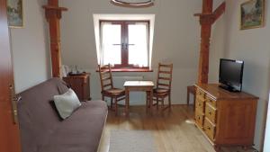 a living room with a couch and a tv and a table at Willa Łuka in Wetlina