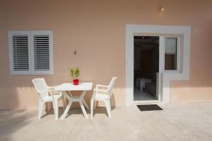 una mesa blanca y sillas junto a una pared en Lara Apartments, en Makarska
