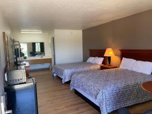 a hotel room with two beds and a television at Brass Door Motel in Gassville