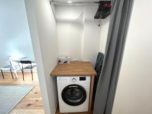 uma lavandaria com máquina de lavar e secar roupa em Cozy studio in Sv Stepono g. em Vilnius