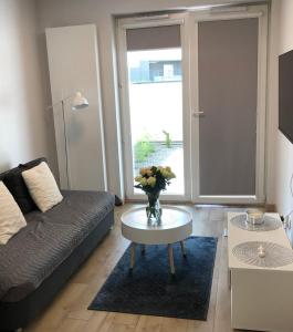 a living room with a couch and a table with flowers on it at Apartament Rzeszów Centrum II in Rzeszów