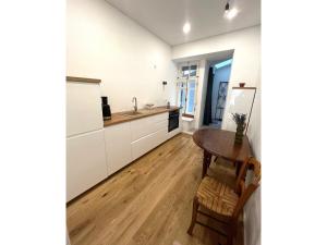 uma cozinha com armários brancos e uma mesa de madeira em Cozy studio in Sv Stepono g. em Vilnius