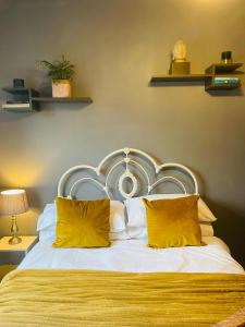 a bedroom with a large bed with yellow pillows at Willow’s Place in Leigh-on-Sea