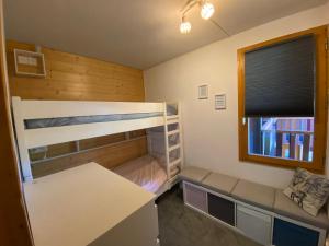 a small bedroom with bunk beds and a window at Appartement Le cheval Blanc VALMOREL 2ch 2sdb in Valmorel
