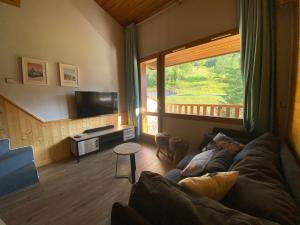 a living room with a couch and a large window at Appartement Le cheval Blanc VALMOREL 2ch 2sdb in Valmorel