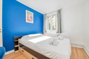 um quarto azul com uma cama com uma parede azul em Cocon chaleureux, 2 chambres, wifi avec fibre em Grenoble