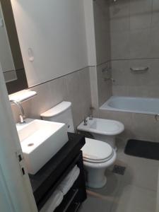 Un baño con inodoro, lavabo y bañera. en Centro Suit, en San Juan