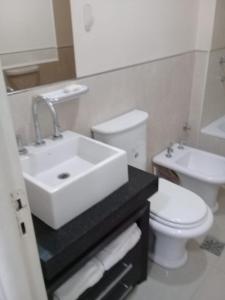 Un baño con un lavabo blanco y un inodoro. en Centro Suit, en San Juan