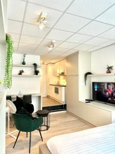 ein Wohnzimmer und eine Küche mit einem grünen Stuhl im Zimmer in der Unterkunft Heart of Grand Place Beautiful Studio in Brüssel