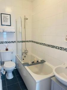 a bathroom with a tub and a toilet and a sink at Willow’s Place in Leigh-on-Sea