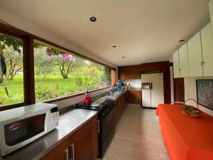 uma cozinha com um balcão com um micro-ondas e uma janela em Naturaleza y calma. Finca a 30 minutos de Bogotá. em Facatativa