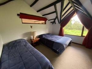 um quarto com 2 camas e uma janela em Naturaleza y calma. Finca a 30 minutos de Bogotá. em Facatativa