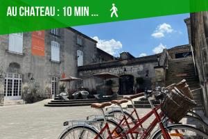 un vélo rouge garé devant un bâtiment dans l'établissement #Nouveau#Cocoon#Wifi#Parking#Biendormiracognac, à Cognac