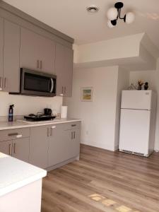 a kitchen with white cabinets and a white refrigerator at Peace down the corner in Mission