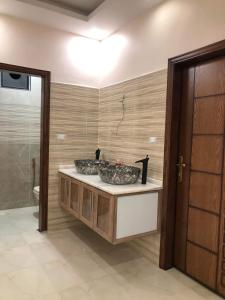 a bathroom with two sinks in a room with a toilet at Souf house in Jerash