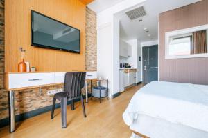 1 dormitorio con 1 cama y TV en la pared en Cozy Studio Flat w Balcony 10 min to Marmara Forum, en Estambul