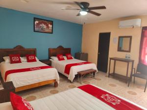 a bedroom with two beds and a ceiling fan at Hotel Posada Santa Elena in Parras de la Fuente