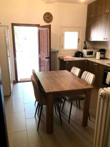 a kitchen with a wooden table and chairs at Villa Erika Mountain Escape in Áno Vlasía