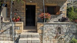 a stone house with a black door and a stone wall at 4 Seasons Villas 2 in Neokhórion