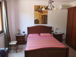1 dormitorio con 1 cama y 2 mesitas de noche en B&B La Pineta, en SantʼAntìoco