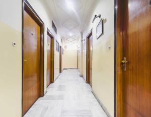 un couloir avec un long couloir et des portes en bois dans l'établissement OYO Flagship Hotel Ajanta, à Āsansol