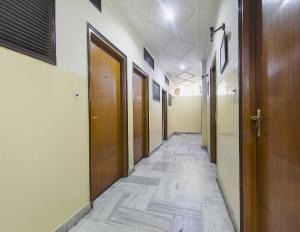 un couloir vide avec des portes en bois et du carrelage dans l'établissement OYO Flagship Hotel Ajanta, à Āsansol
