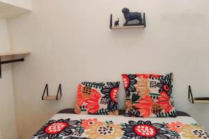 una cama con almohadas coloridas y un gato en un estante en A L ESCALE PASSA PAÏS, en Le Poujol-sur-Orb
