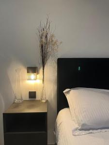 a bedroom with a bed and a night stand with a lamp at Privé kamer met eigen douche en lavabo in Bruges
