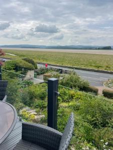 a balcony with chairs and a view of a road at Watersedge Retreat, views, sunsets, dogs welcome in Sandside