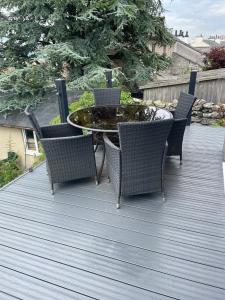 a patio with a table and chairs on a deck at Watersedge Retreat, views, sunsets, dogs welcome in Sandside