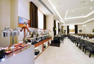 un restaurante con una línea de buffet con mesas y sillas en SKAF HOTEL LLC, en Dubái
