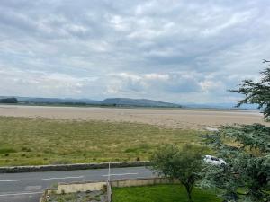 a view of a beach with a road and a field at Watersedge Retreat, views, sunsets, dogs welcome in Sandside