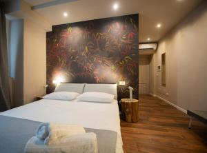 San Benedetto Rooms في كريما: غرفة نوم بسرير كبير عليها لوحة على الحائط