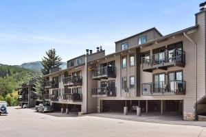 un edificio de apartamentos con balcones y un coche aparcado en un aparcamiento en Snowmass Mountain D1, en Snowmass Village