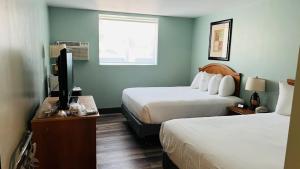 a hotel room with two beds and a flat screen tv at Adventure Inn - Glenwood Springs in Glenwood Springs
