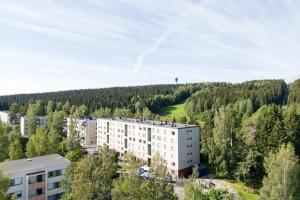 an apartment building in the middle of a forest at Moderni ja tilava kolmio + sauna in Kuopio