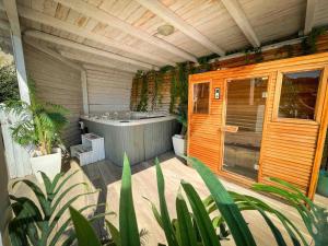 una vasca da bagno all'aperto in una stanza con piante di Starsbox con piscina e idromassaggio a Celle Ligure