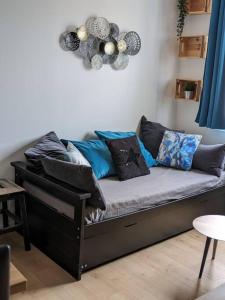 - un canapé avec de nombreux oreillers dans l'établissement "Le Royan" appartement proche gare et plage, à Royan