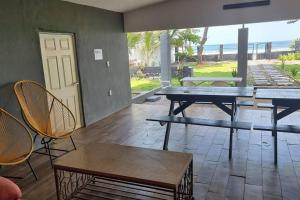 un patio con mesa de ping pong y sillas en Hermosa Casa de Playa DejaBlue SV (con Mini Golf), en La Libertad