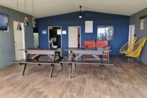 dos mesas de picnic en una habitación con una pared azul en Hermosa Casa de Playa DejaBlue SV (con Mini Golf), en La Libertad