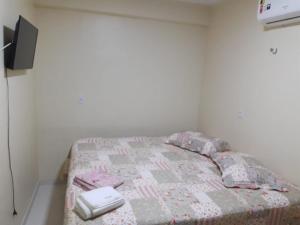 a small bedroom with a bed with a comforter at Casa da Deusa in Belém