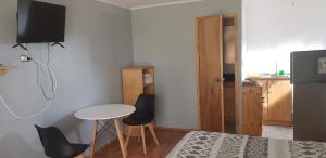 um pequeno quarto com uma cama, uma mesa e cadeiras em Strandvagen Maitencillo em Puchuncaví
