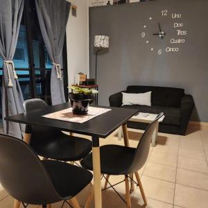 a dining room table with chairs and a clock on the wall at At Home CdelU in Concepción del Uruguay