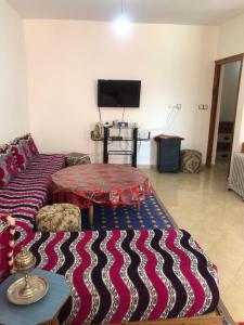 a living room with a couch and a tv at Vittel Ifrane Large and Beautiful Apartment in Ifrane