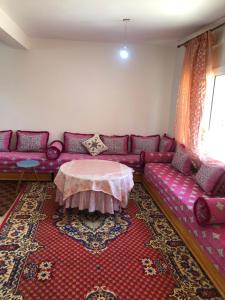sala de estar con sofá púrpura y mesa en Vittel Ifrane Large and Beautiful Apartment en Ifrane