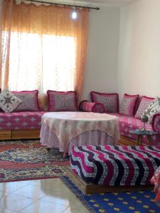 ein Wohnzimmer mit einem Sofa und einem Tisch in der Unterkunft Vittel Ifrane Large and Beautiful Apartment in Ifrane