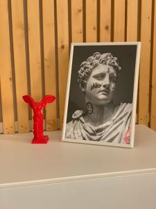 a picture of a bust of a woman next to a red toy at Studio Via Romana Vaison La Romaine in Vaison-la-Romaine